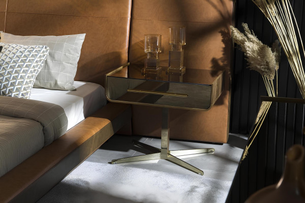 Säng med design och två nattygsbord i glas